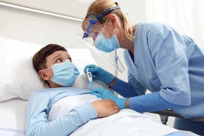 shutterstock_1771858736 Nurse checks temperature of hospitalized boy