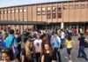 Students gathered outside a school building entrance