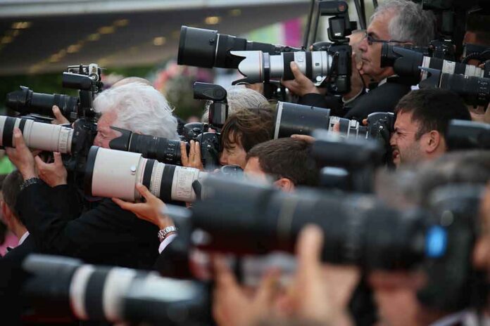 shutterstock_196325180 Photographers with large telephoto lenses crowded together