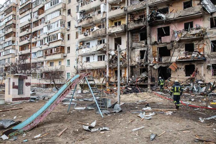 shutterstock_2129012939 Damaged apartment building behind a playground slide