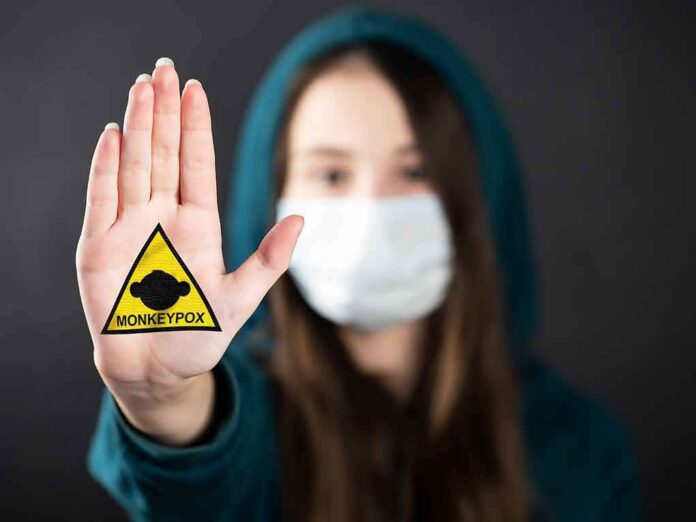 Person in mask holding up palm with monkeypox warning patch