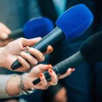 Gunshots ERUPT in Foreign Senate Reporters holding colorful microphones