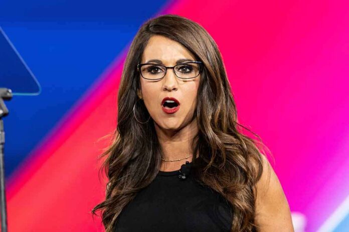 Woman with glasses speaking on stage with colorful backdrop