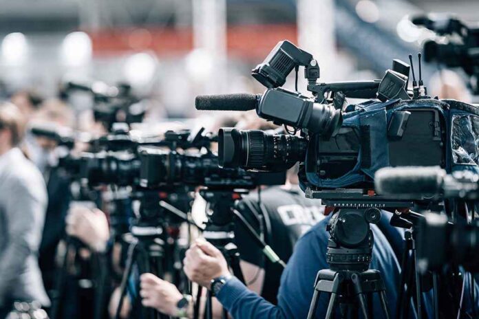 Broadcast cameras on tripods at a press event