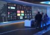 cybersecurity operations room with large data dashboards and people discussing