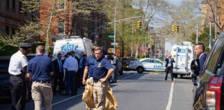 Police officers and investigators at a blocked city street scene