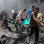 Rescuers carry an injured person on a stretcher through rubble