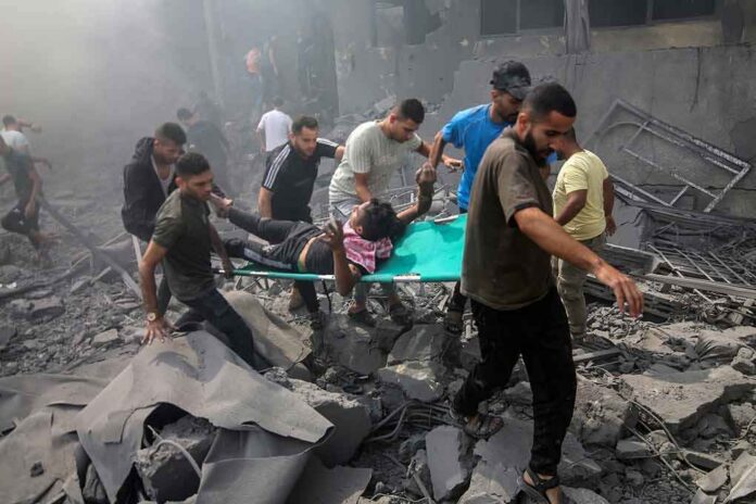 Rescuers carry an injured person on a stretcher through rubble
