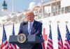 Trump Tells Fox News: Iran Ultimatum Looms Donald Trump speaking at a podium with American flags and a ship in the background