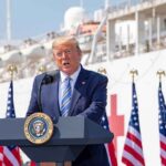 Trump Tells Fox News: Iran Ultimatum Looms Donald Trump speaking at a podium with American flags and a ship in the background