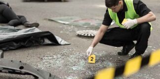 Forensic investigator marking evidence at crash scene