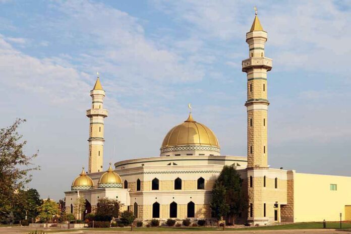 shutterstock_312777998 Mosque with golden dome and two tall minarets under a partly cloudy sky