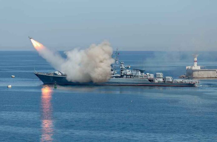 shutterstock_533229181 Warship launching a missile at sea