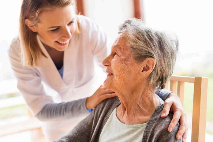 shutterstock_735361786 Caregiver smiling at an elderly woman