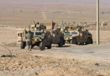 View From Baghdad as Last US Troops Leave Iraq Soldiers near armored vehicles in a desert