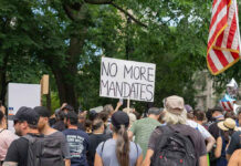 Here’s How Many ICE Detainers Sanctuary State Has Rejected Crowd holds No More Mandates sign at protest.