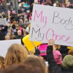 Protesters hold signs at a crowded march
