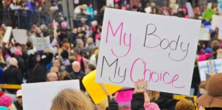 Protesters hold signs at a crowded march