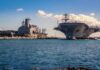 USS Abraham Lincoln Returns to U.S After Controversial 300-Day Deployment Aircraft carrier and support ships docked at a naval harbor