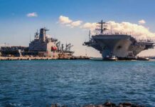 USS Abraham Lincoln Returns to U.S After Controversial 300-Day Deployment Aircraft carrier and support ships docked at a naval harbor