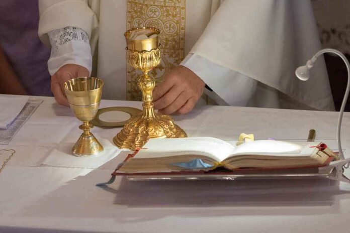 Priest at altar with chalices and open book