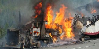 Burning semi-truck cab and trailer on highway