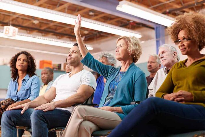 shutterstock_1380554498 Brian Yorkey in a community meeting as a woman raises her hand