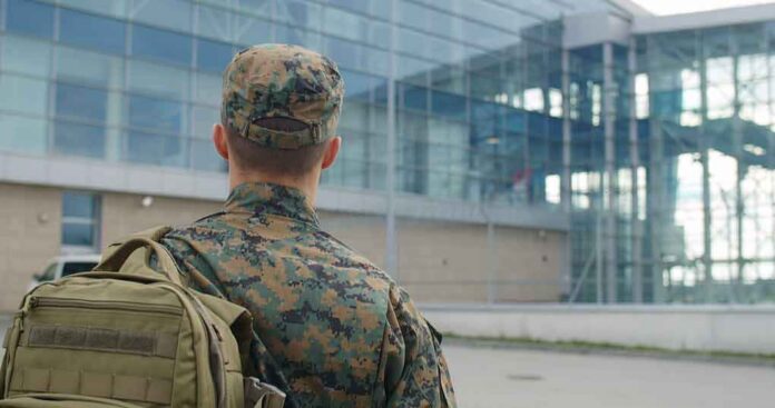 soldier in camouflage with backpack outside modern glass building