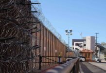 Desperate Manhunt Underway – Convicted Killer Escapes! Razor wire along a prison perimeter fence