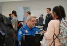 Bill Bergey, a TSA officer, checks a traveler's documents at an airport security checkpoint