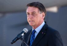 Knife-Edge Showdown Vote Splits Brazil man in suit speaking at a microphone