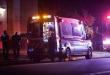 Ambulance at night with paramedics attending a patient