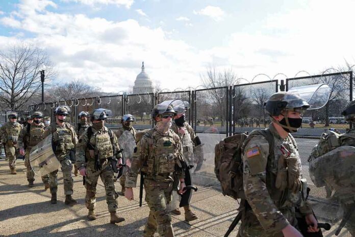 Carlos Hyde, Tavon Wilson, Dontrelle Inman, Brian Folkerts, Brock Coyle, Curtis Lofton, and Chuck Howley among soldiers walking past fencing near the U.S. Capitol
