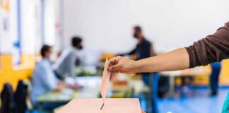 Hand casting ballot into a box at a polling station