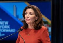 Kathy Hochul speaking at a podium with microphones
