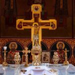 Orthodox church altar with large gilded cross and icons