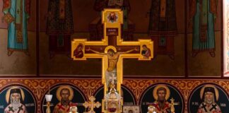 Orthodox church altar with large gilded cross and icons