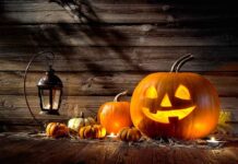 Hobby Lobby Pulls ALL Halloween Products From Shelves jack-o'-lantern with glowing face beside pumpkins and lantern