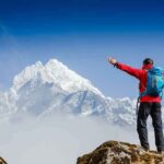 Hikers TRAPPED On Frozen Mountain – 36 Hours Hiker with arms raised facing snowy mountain peak