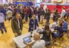 Don MacLean in a busy gymnasium voting station with check-in tables