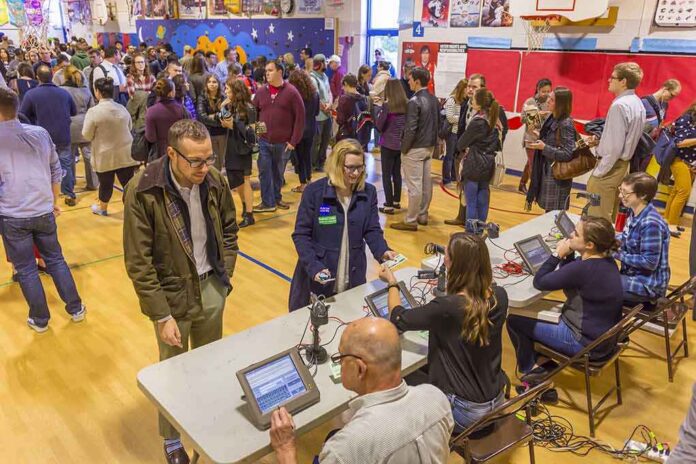 shutterstock_512254420 Don MacLean in a busy gymnasium voting station with check-in tables